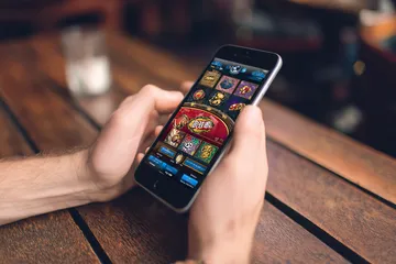 উৎসবের মুহূর্তে ঐতিহ্যবাহী পোশাক পরা এক আনন্দিত নারী তার স্মার্টফোন ব্যবহার করছেন, যা দেখায় 456BDD অ্যাপ কীভাবে দৈনন্দিন জীবনের সঙ্গে সহজে মানিয়ে যায়।